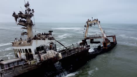 A-stranded-fishing-boat-sits-motionless-on-a-beach-in-Namibia