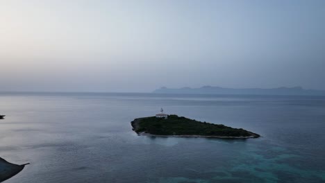 Leuchtturm-Auf-Einer-Kleinen-Insel-Bei-Sonnenaufgang-Mit-Kristallklarem-Wasser