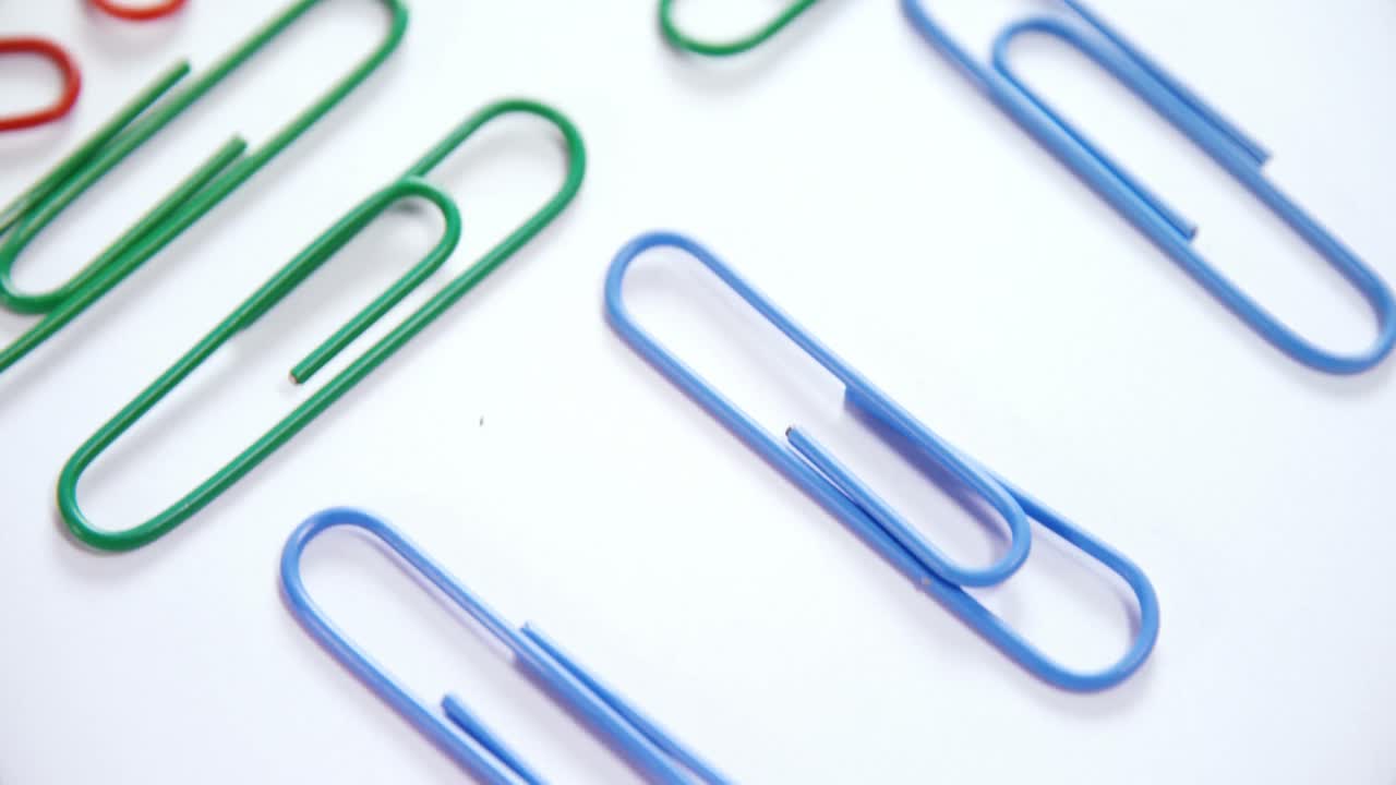 Colorful paper clips arranged on white background 4k