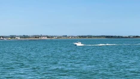 White-Speedboat-Cruising-Amidst-the-Stunning-Beauty-of-a-Sunny-Day-with-Clouds,-Framed-by-the-Majestic-Mourne-Mountains-in-Northern-Ireland