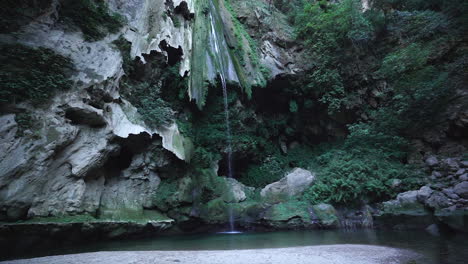 Arroyo-Que-Fluye-Desde-Colinas-Rocosas-Cubiertas-De-Musgo-Y-Follaje-En-Un-Lago-Tranquilo-En-Chefchaouen,-Marruecos