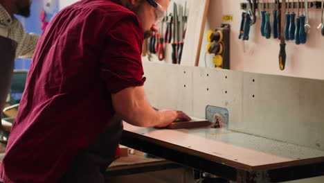 manufacturer and apprentice performing tasks on wood shaper