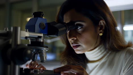 woman looking into a microscope in a laboratory