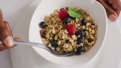 video de cereales y frutas en tazón de cerámica en la encimera blanca de la cocina