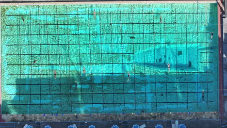 Top-down-aerial-footage-of-a-large-swimming-pool-with-many-people-doing-morning-exercises-in-Rio-de-Janeiro