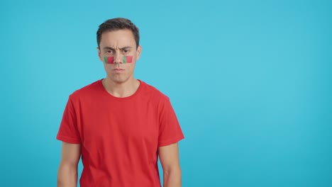 Dignified and serious man with portuguese flag painted on face
