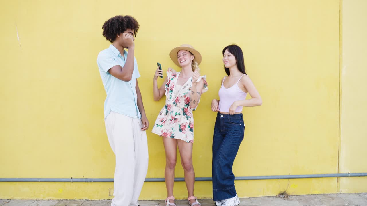 Amici che si divertono e ballano davanti a un muro giallo