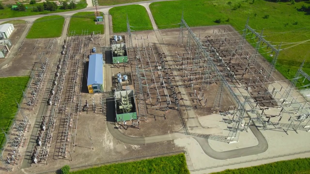 Hochspannungs-Umspannwerk und Batteriespeicherpark erzeugen saubere Energie mit einem Netzwerk aus Transformatoren und Stromleitungen, was nachhaltige Stromerzeugungstechnologie demonstriert.