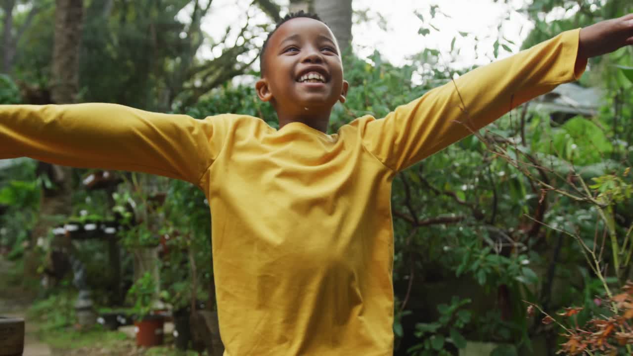 Happy african american boy running and playing in garden