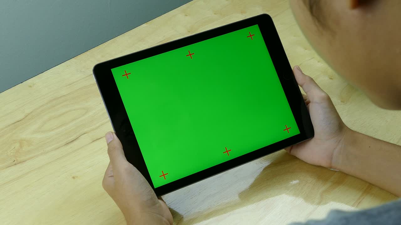 녹색 화면을 가진 태블릿을 사용하는 것