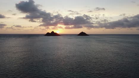 4k cinematic crane-zoom drone shot of early sunrise over two islands and the ocean near lanikai beach in oahu