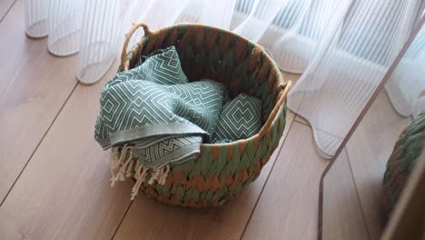 woven basket with patterned textile on wooden floor