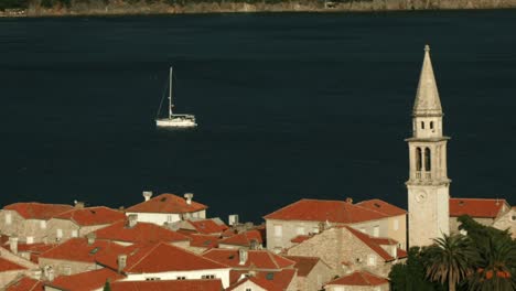 coastal town with sailboat and church tower