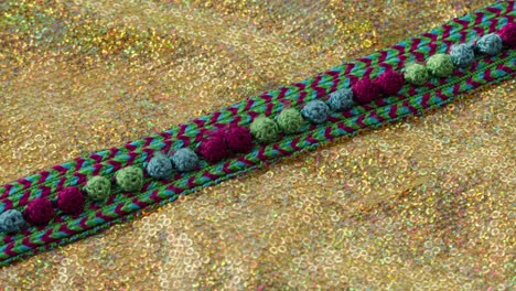 patrón de color tejido en tela brillante dorada con pañuelos de primer plano. confección de ropa festiva. fondo brillante dorado. concepto de coser vestido de año nuevo