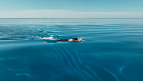 person swimming in the calm blue ocean