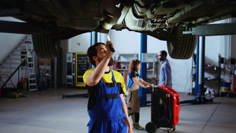 Expert-in-garage-works-on-suspended-car