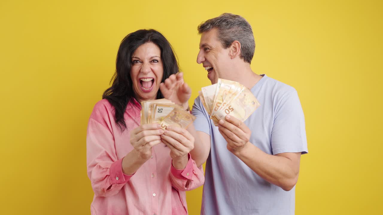 Happy couple holding Euro banknotes