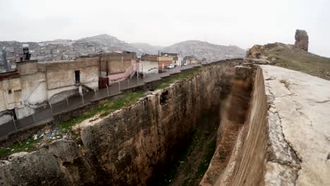 la zanja hecha a mano del castillo de urfa divide las ruinas y los barrios marginales nieve y lluvia