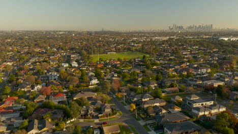 aerial ramp shot showing suburban sporting field and revealing the endless city of greater melbourne