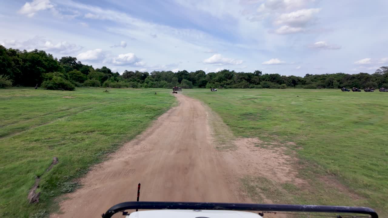 POV jeep safari through the expansive landscapes of Kaudulla National Park, Sri Lanka.