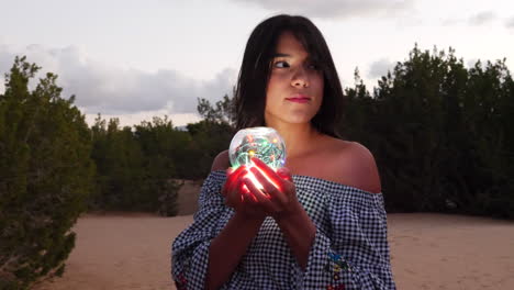 A gorgeous woman sorceress wandering in a fantasy landscape with a magical spiritual orb glowing in illuminated light