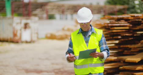 trabajador masculino examinando la pila de tablones 6