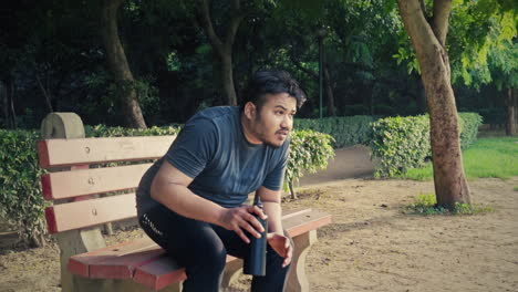 indian young fat man resting after jogging at public park