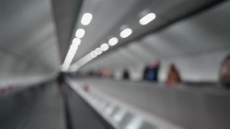 escaleras mecánicas borrosas en el metro y personas irreconocibles.