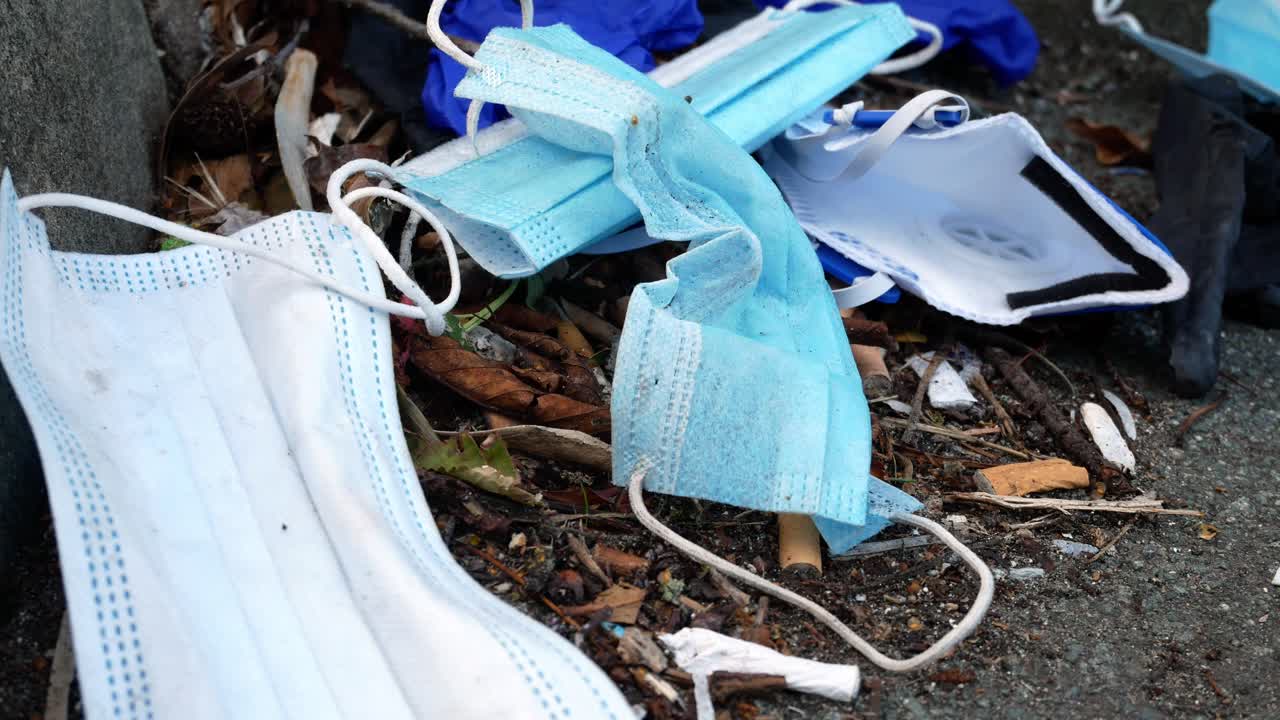 거리 연석 하강 돌리 오른쪽에 담배 오염 쓰레기 사이 더러운 일회용 코로나 바이러스 얼굴 마스크와 라텍스 장갑