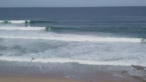top down aerial view of turquoise blue ocean waves breaking on the shore of idyllic tropical sand beach