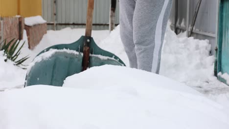 clearing white snow frost and ice with snow shovel or spade - close up