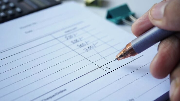 Close-up of a Hand Writing on an Invoice