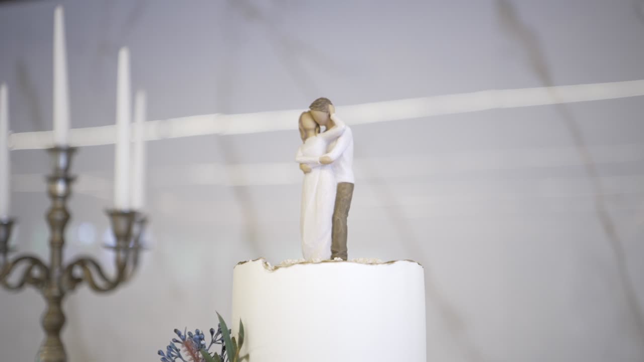 포옹하는 커플의 피겨린으로 장식된 우아한 웨딩 케이크