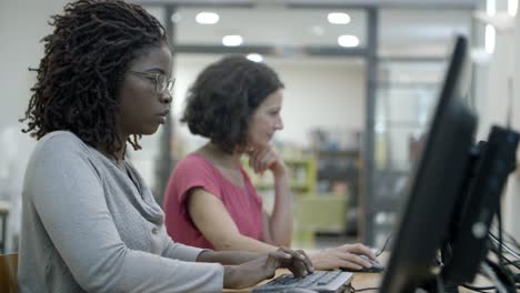 side view of two women working with computers