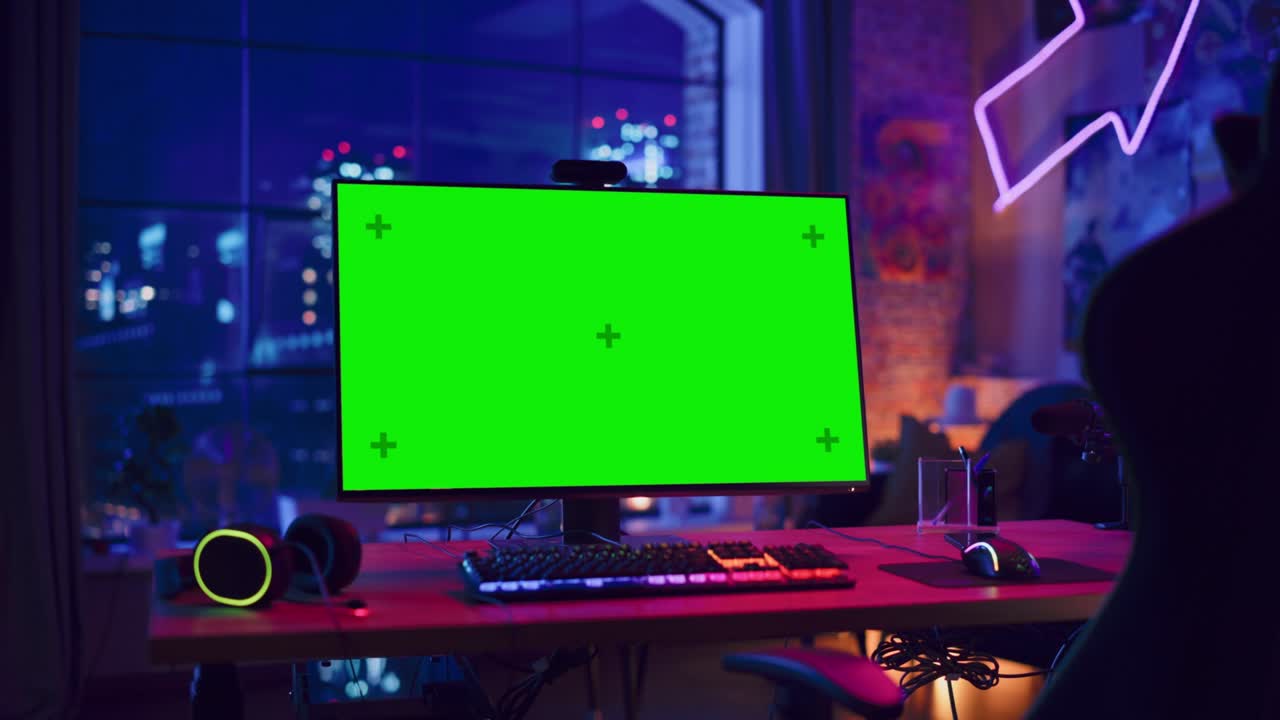 Gaming at Home: Empty Gaming Station with Player's Personal Computer with Green Screen Chroma Key Display Standing on a Wooden Desk in Stylish Loft Apartment with Neon Lights. Zoom In Shot.