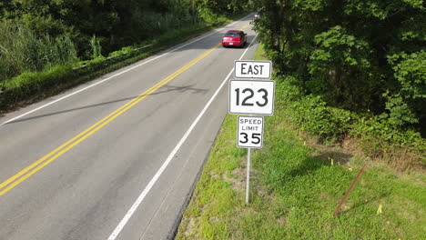 aerial low drone shot of cars passing road signs, static loopable