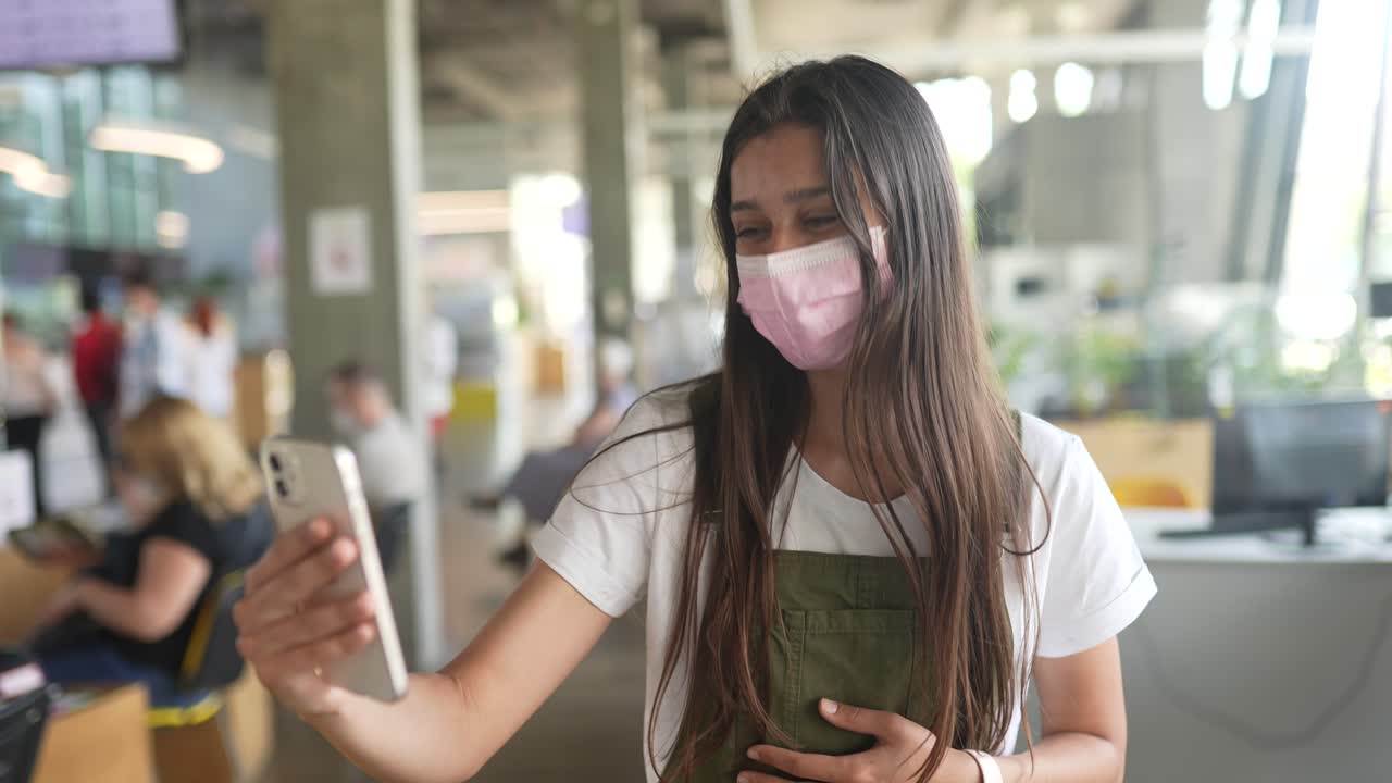 대중 앞에서 스마트폰을 사용하는 마스크를 착용한 여성