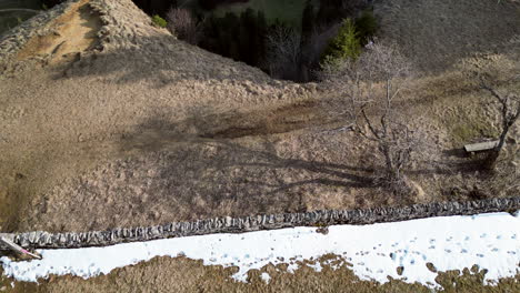 Aerial-pan-down-going-over-tall-rock-cliff,-Wandfluh-Solothurn,-Switzerland