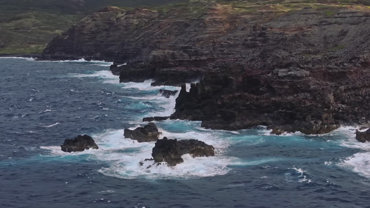 amplia toma aérea de la costa rocosa de maui con mares agitados y olas chocando contra las rocas