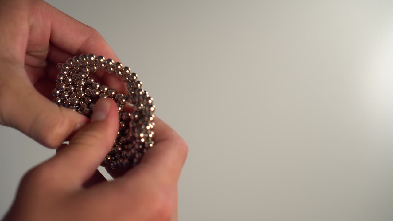 아이는 그의 손으로 공의 자기 퍼즐을 수집합니다.