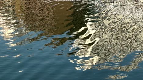 rippling water reflecting light with a hint of surrounding architecture