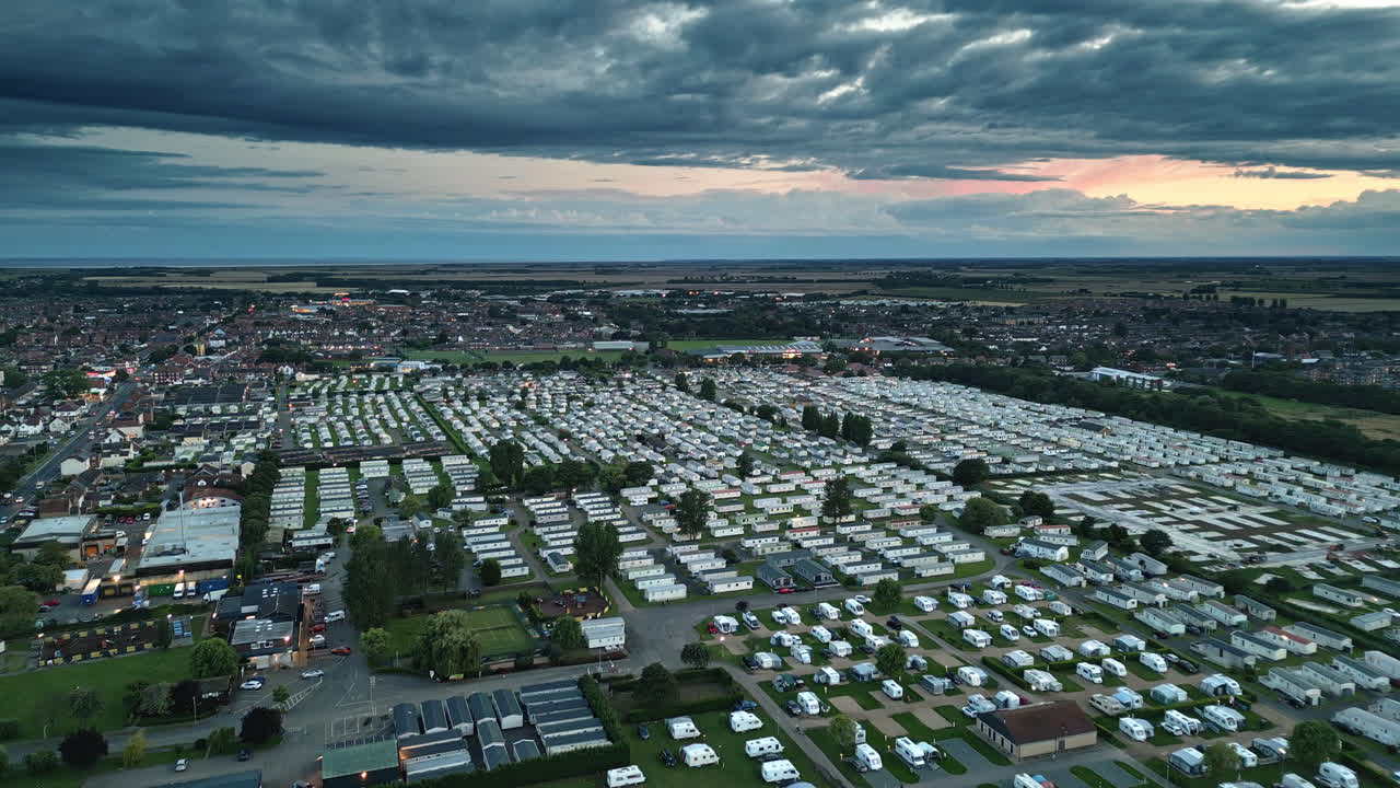 Sunset drone video of Skegness seaside town: holiday park, beach, caravans, and sweeping landscapes