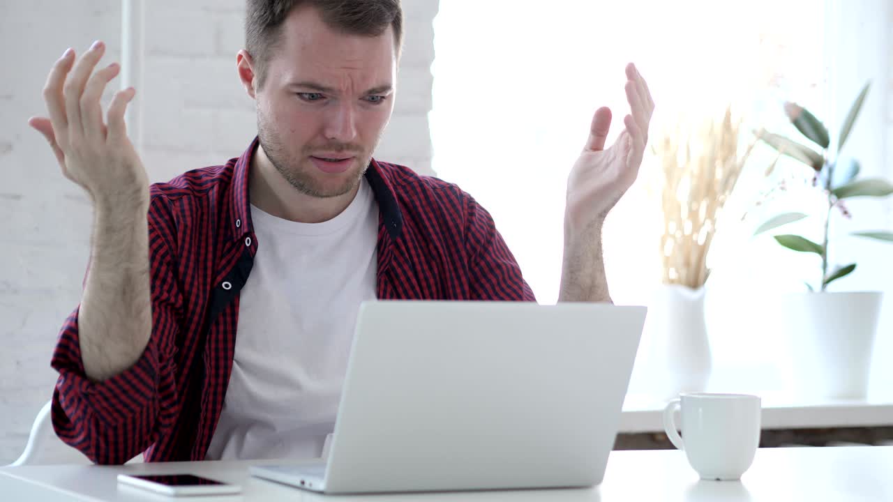 노트북에서 일하는 실망한 젊은이