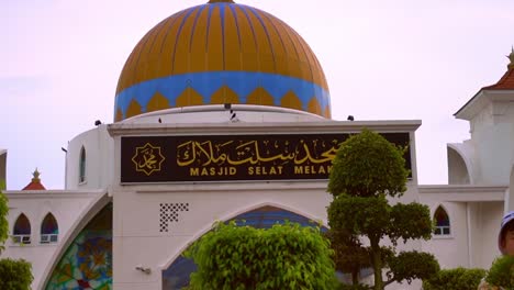 signage of melaka straits mosque written in malay and english letters - close up shot