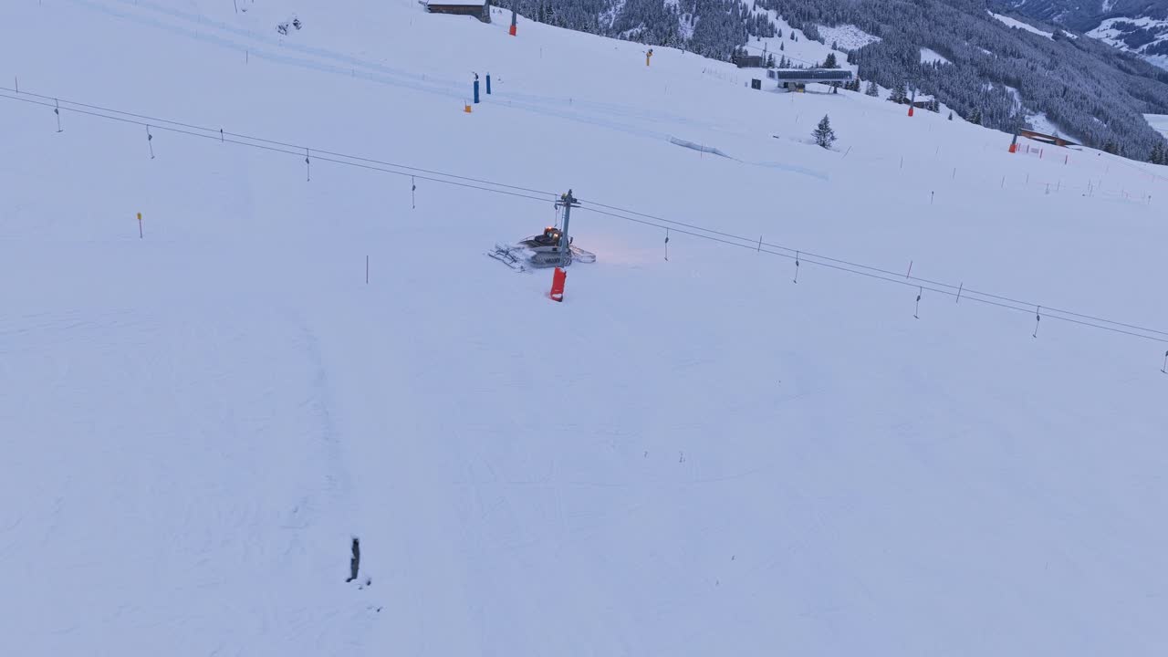 Aerial footage of Zillertal Arena with pistebully vehicles grooming ski runs in Krimml and Königsleiten, Austria, with massive snow packs and surrounding peaks