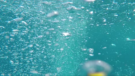 nadando a través de burbujas de oxígeno en el profundo océano azul