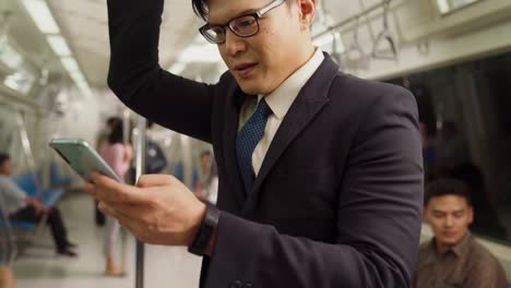 businessman using mobile phone on public train