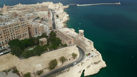 Upper-Barrakka-Gardens-in-Valletta-City-on-Malta-Island-with-Palm-Trees-and-Ancient-Greek-Temple,-Aerial-Slide-Dolly-Right