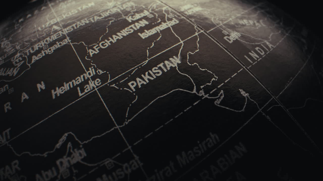 Close-up view of a world globe focusing on the Asian region, highlighting Pakistan and Afghanistan.