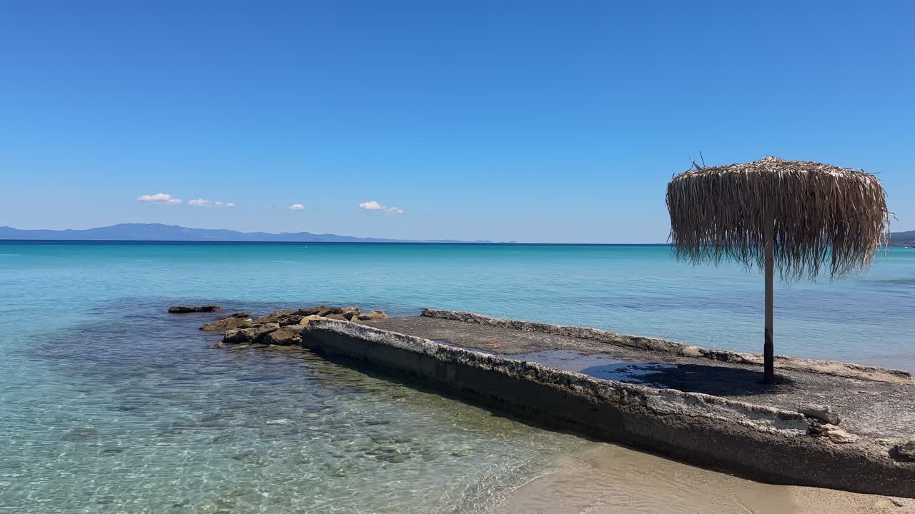 Stunning beach scene in Halkidiki, Greece, with elegant sunbeds facing the crystal-clear turquoise sea. A perfect summer escape in the heart of the Aegean.